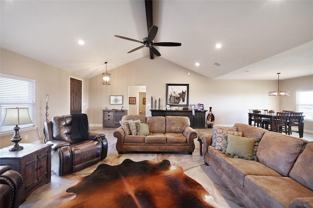 living room featuring vaulted ceiling with beams and ceiling fan with notable chandelier