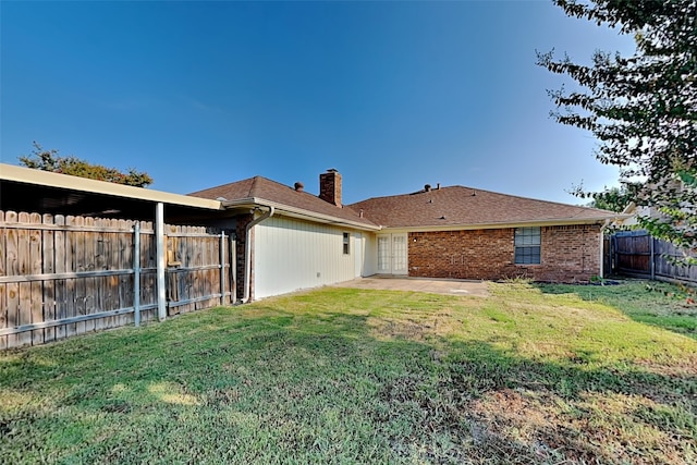 back of property with a yard and a patio area