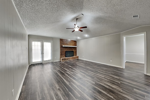 unfurnished living room featuring dark hardwood / wood-style flooring, ceiling fan, a fireplace, and french doors