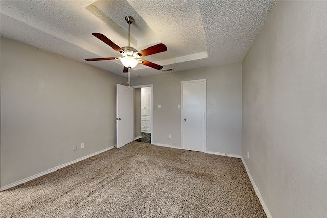 carpeted spare room featuring ceiling fan and a textured ceiling