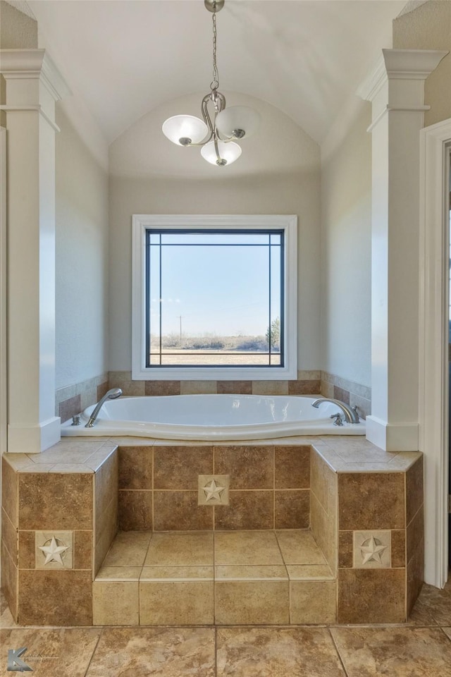 bathroom with ornate columns, vaulted ceiling, and tiled tub