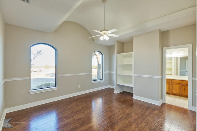 empty room with plenty of natural light, dark hardwood / wood-style floors, and ceiling fan