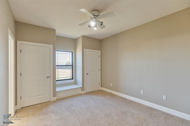 interior space with light colored carpet and ceiling fan