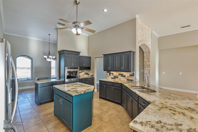 kitchen featuring sink, tasteful backsplash, appliances with stainless steel finishes, kitchen peninsula, and pendant lighting