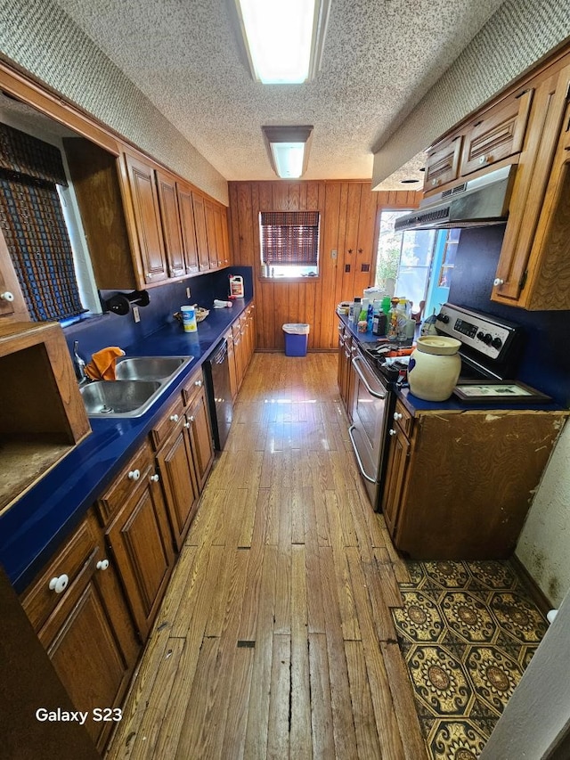 kitchen featuring sink, stainless steel electric range oven, light hardwood / wood-style flooring, a textured ceiling, and black dishwasher