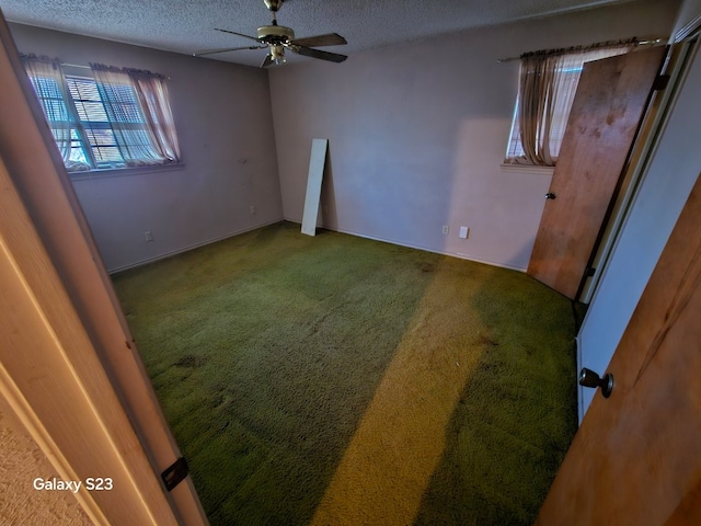 unfurnished room featuring ceiling fan, carpet, and a textured ceiling