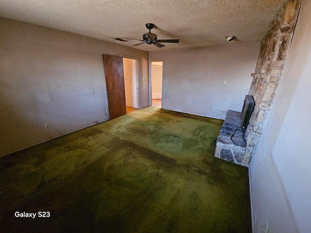 interior space featuring ceiling fan, light carpet, and a textured ceiling