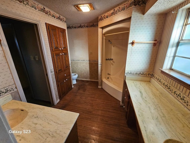 full bathroom featuring hardwood / wood-style flooring, vanity, a textured ceiling, and shower / tub combination