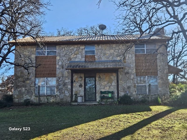 rear view of property featuring a lawn