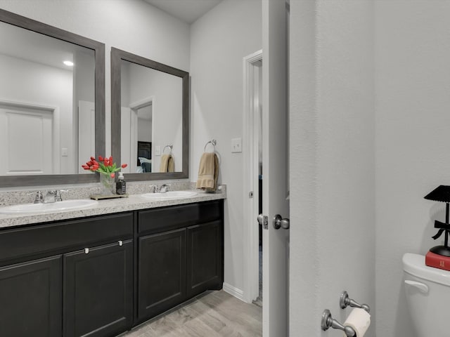 bathroom with vanity, toilet, and hardwood / wood-style floors