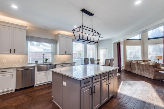 kitchen with white cabinetry, sink, dishwasher, and a kitchen island