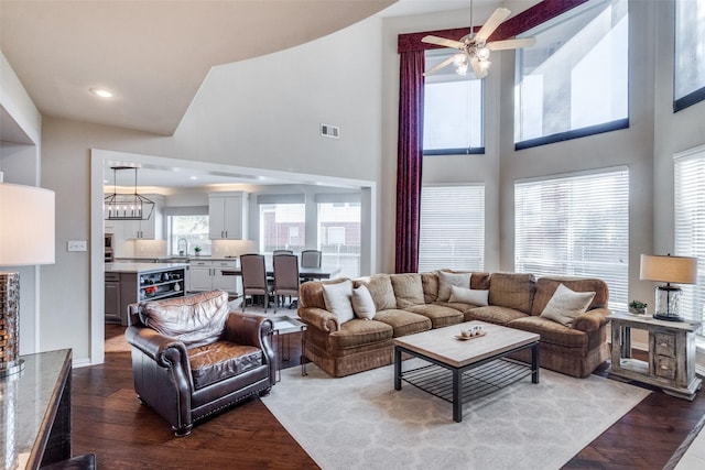 living room with hardwood / wood-style flooring, a high ceiling, and ceiling fan