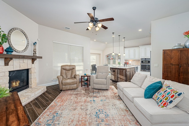 living room with sink, a fireplace, and ceiling fan