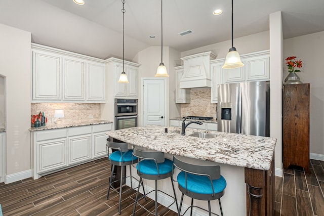 kitchen featuring premium range hood, appliances with stainless steel finishes, sink, and backsplash