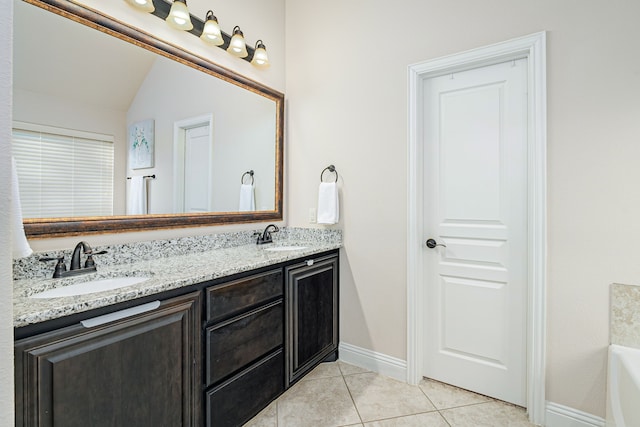 bathroom featuring vaulted ceiling, vanity, tile patterned flooring, and a tub