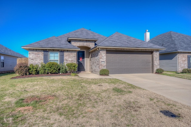 view of front of property featuring a garage and a front lawn