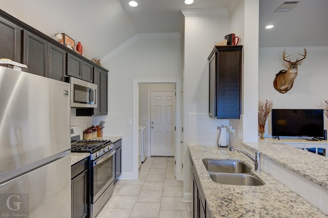 kitchen featuring light stone countertops, appliances with stainless steel finishes, sink, and lofted ceiling