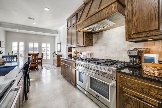 kitchen featuring tasteful backsplash, appliances with stainless steel finishes, and dark stone counters