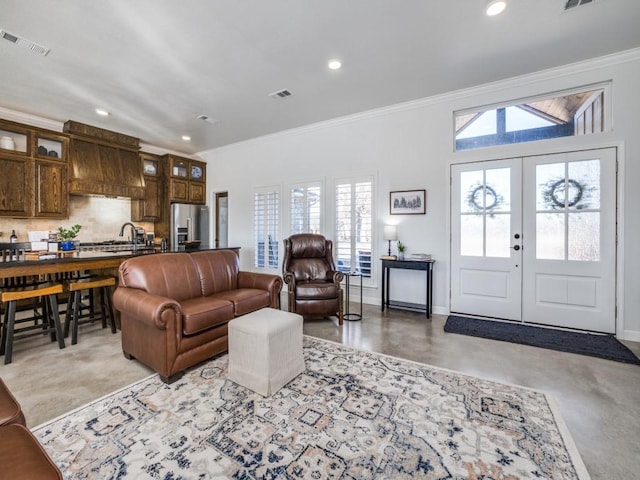 living room with ornamental molding, sink, and french doors