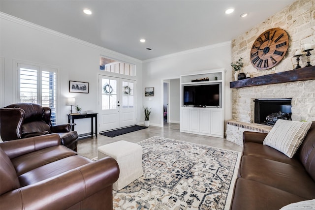 living room with crown molding, a stone fireplace, and french doors