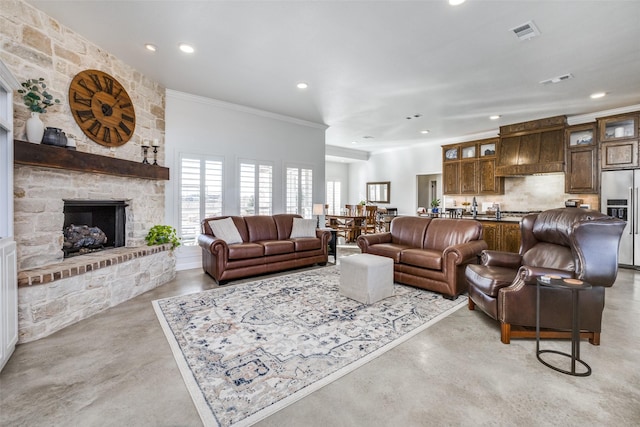 living room featuring crown molding and a stone fireplace