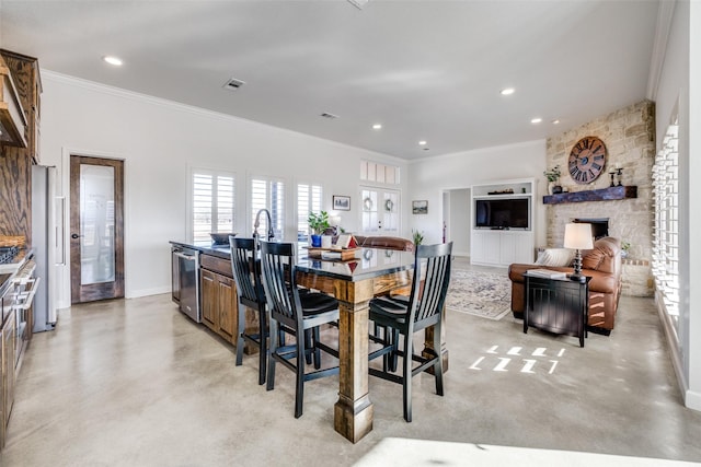 dining room with ornamental molding, a fireplace, and sink