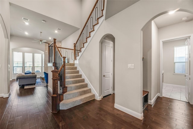 stairs with wood-type flooring and ceiling fan