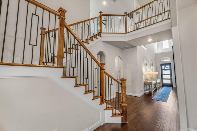 stairway featuring hardwood / wood-style flooring and a high ceiling