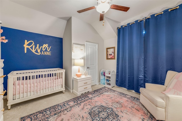 bedroom featuring a nursery area, ceiling fan, lofted ceiling, and carpet floors