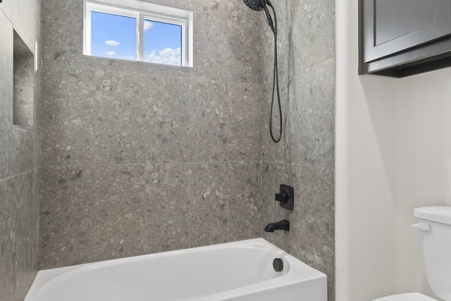 bathroom with toilet and tiled shower / bath combo