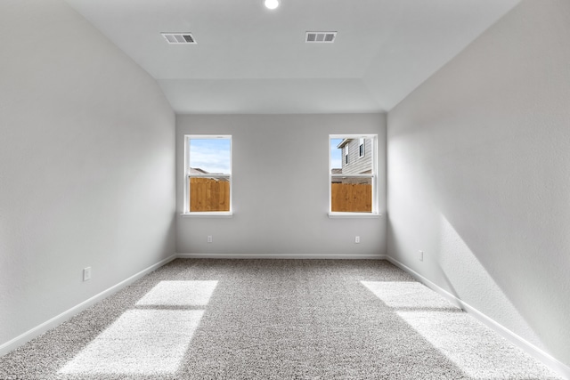 empty room featuring lofted ceiling and carpet