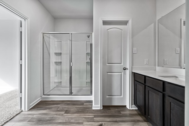 bathroom featuring hardwood / wood-style flooring, vanity, and a shower with shower door