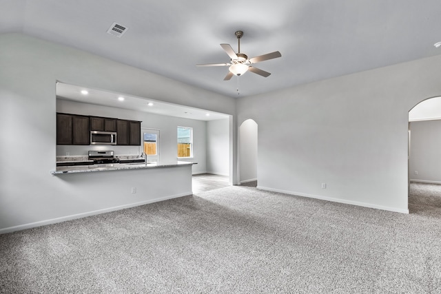 unfurnished living room featuring sink, light colored carpet, and ceiling fan