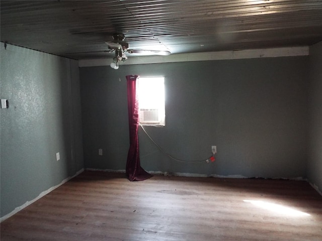 empty room with hardwood / wood-style flooring, ceiling fan, and cooling unit