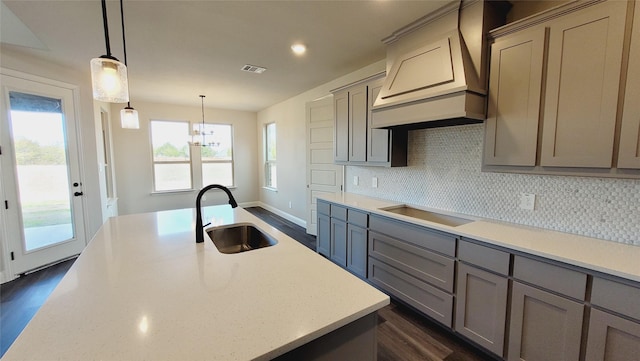 kitchen with sink, backsplash, hanging light fixtures, custom range hood, and black electric cooktop