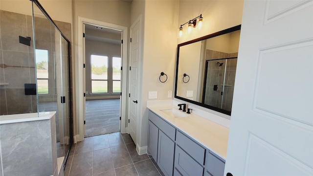 bathroom featuring tile patterned flooring, an enclosed shower, and vanity