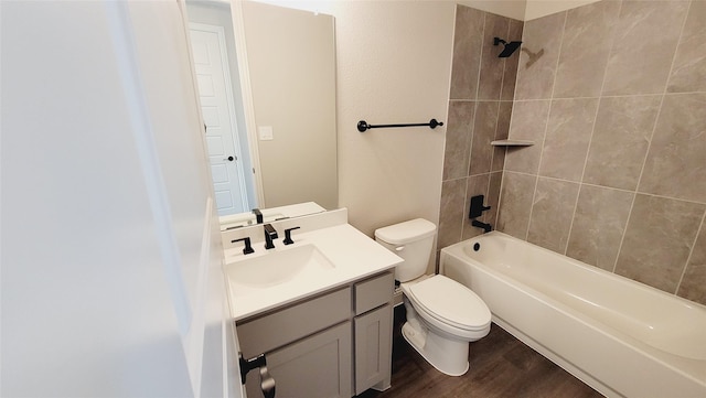 full bathroom with hardwood / wood-style flooring, vanity, tiled shower / bath combo, and toilet