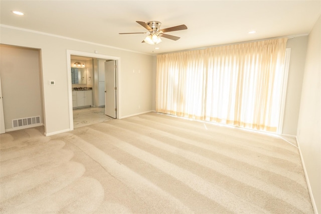 spare room featuring ornamental molding, light colored carpet, and ceiling fan