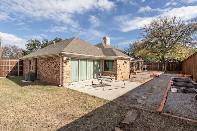 rear view of house featuring central AC unit, a yard, and a patio