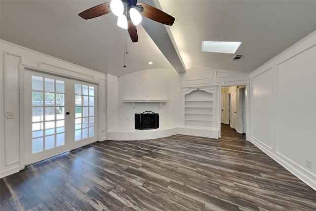 unfurnished living room featuring a brick fireplace, built in shelves, lofted ceiling with beams, and dark hardwood / wood-style floors