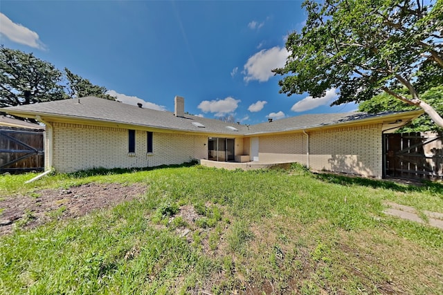 rear view of house featuring a patio area and a lawn