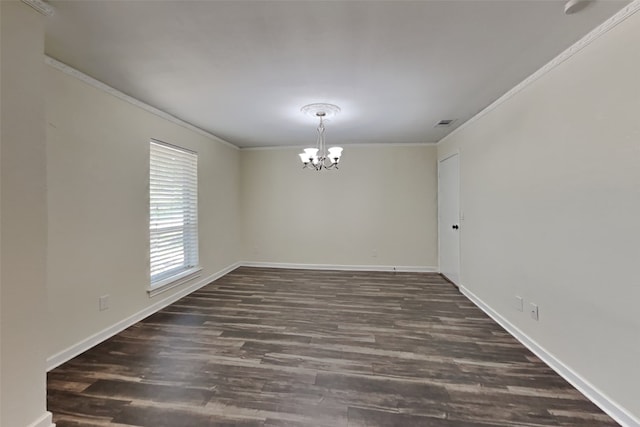 spare room featuring dark hardwood / wood-style flooring, ornamental molding, and an inviting chandelier