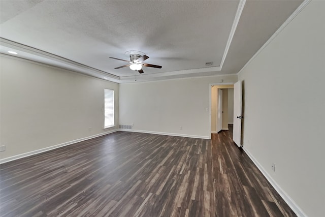 empty room with dark wood-type flooring, ceiling fan, a raised ceiling, and a textured ceiling