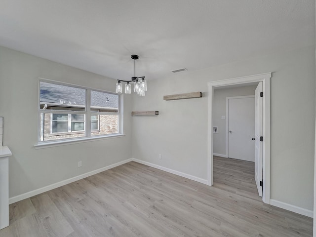 interior space with a chandelier and light hardwood / wood-style floors