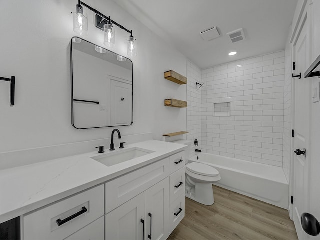 full bathroom featuring vanity, toilet, tiled shower / bath combo, and hardwood / wood-style floors