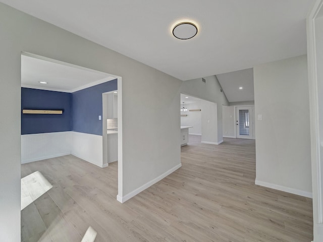 empty room with vaulted ceiling and light wood-type flooring