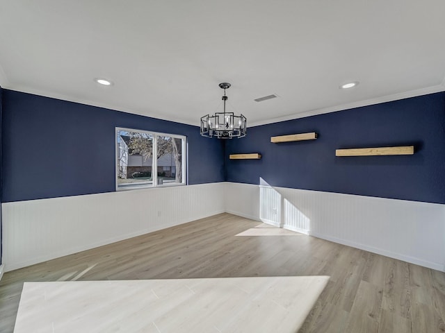 unfurnished dining area featuring a notable chandelier, crown molding, and light hardwood / wood-style flooring