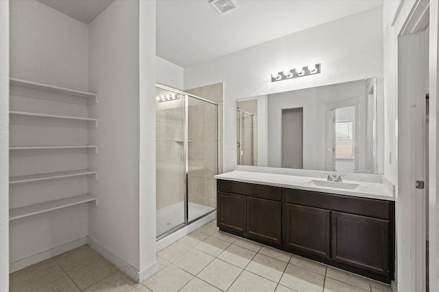 bathroom featuring tile patterned flooring, vanity, and walk in shower