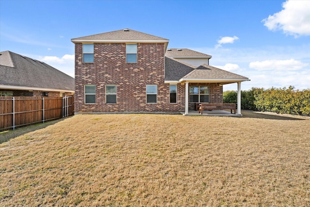 rear view of house with a patio area and a lawn