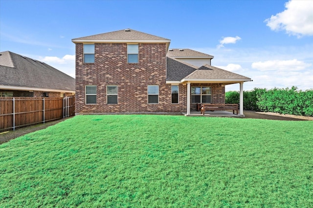 rear view of house featuring a yard and a patio